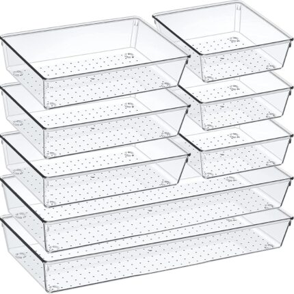 An 8-pack set of clear acrylic drawer organizers with non-slip pads, shown neatly arranged in a drawer, holding various small