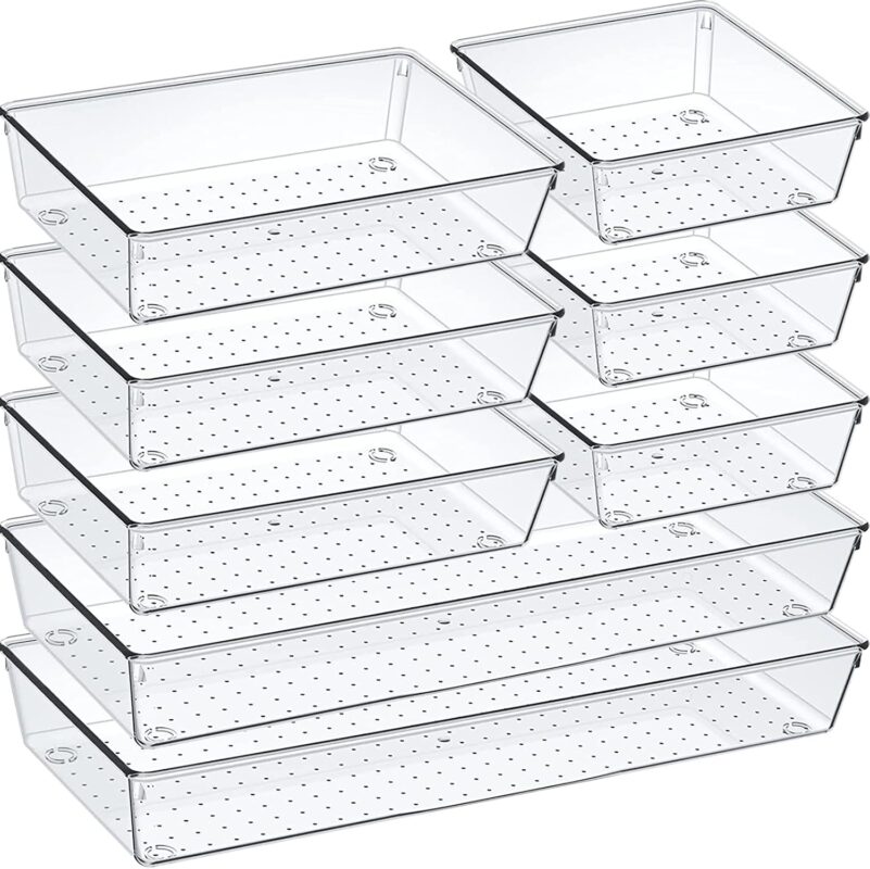 An 8-pack set of clear acrylic drawer organizers with non-slip pads, shown neatly arranged in a drawer, holding various small