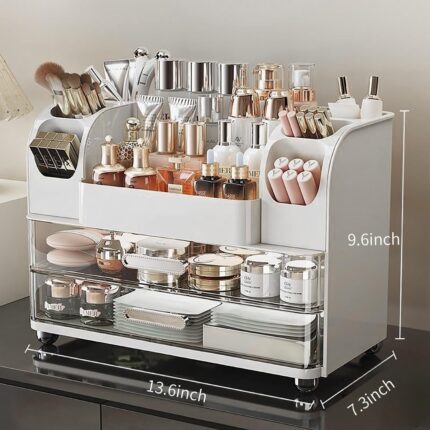 Heaime white acrylic makeup organizer with two drawers and an open top section holding brushes, lipsticks, and skincare bottl