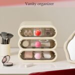 MavHubrix 3-Tier Cream White Makeup Organizer with colorful knobs on a vanity, holding cosmetics and small items.