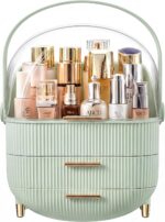 A white and gold NestOrganix makeup organizer with three drawers and a clear top cover, filled with various cosmetics.