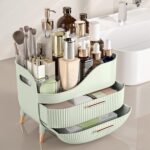 Pajiriona sage green makeup organizer with two drawers and a top compartment, featuring a handle, displayed on a vanity.