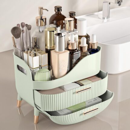 Pajiriona sage green makeup organizer with two drawers and a top compartment, featuring a handle, displayed on a vanity.