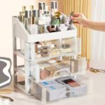 White PTBSZCWY makeup organizer with three pull-out drawers and an open top compartment for displaying cosmetics.