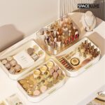 A cream white SpaceLuxe 3-tier makeup organizer with a rotating brush holder, filled with makeup and skincare products.