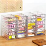 Four clear acrylic makeup organizers stacked and side-by-side, showcasing multiple drawers filled with various cosmetics and