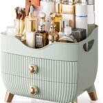 Green YGJT makeup organizer with two drawers and a top compartment, featuring a golden handle and filled with various cosmeti
