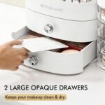 White countertop makeup organizer with two drawers and an open top compartment, filled with various cosmetic products.
